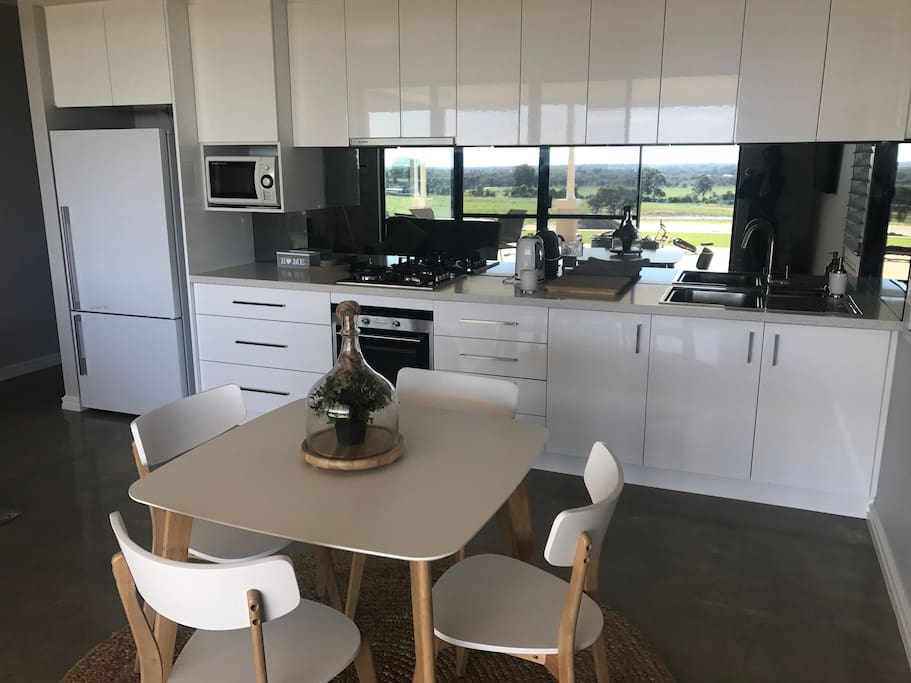 Kitchen , dining area , just look at the view through the splashback ! Fridge /freezer , microwave , oven and gas cooktop . Kettle and toaster , tea & coffee included . Triple filtered rain water for drinking