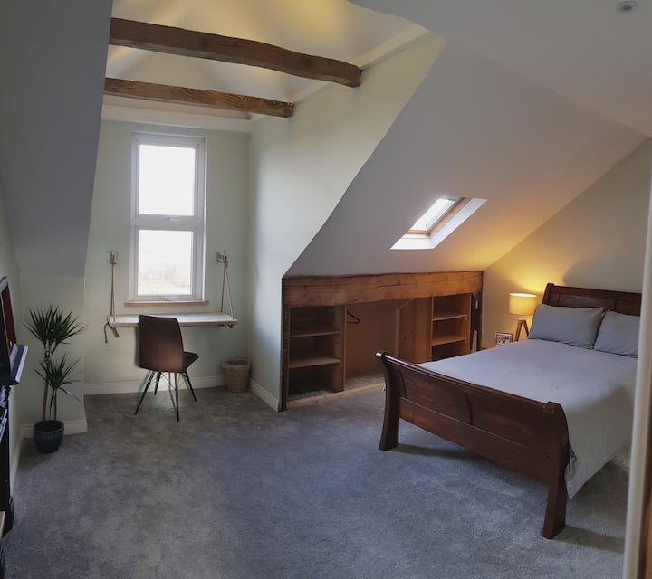 Chumba kikubwa cha dari kilichopambwa. Chumba kimefurika na mwanga wa asili.