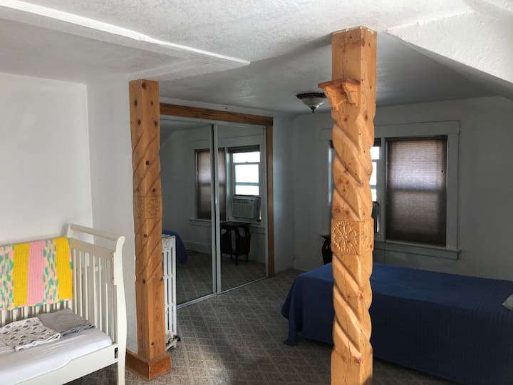 Twee eenpersoonsbedden en ledikant in slaapkamer boven