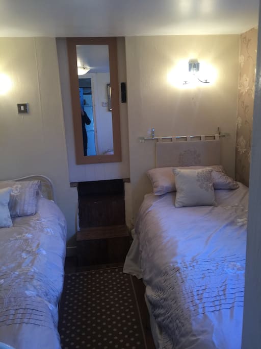 Cosy twin bedroom leading to bathroom