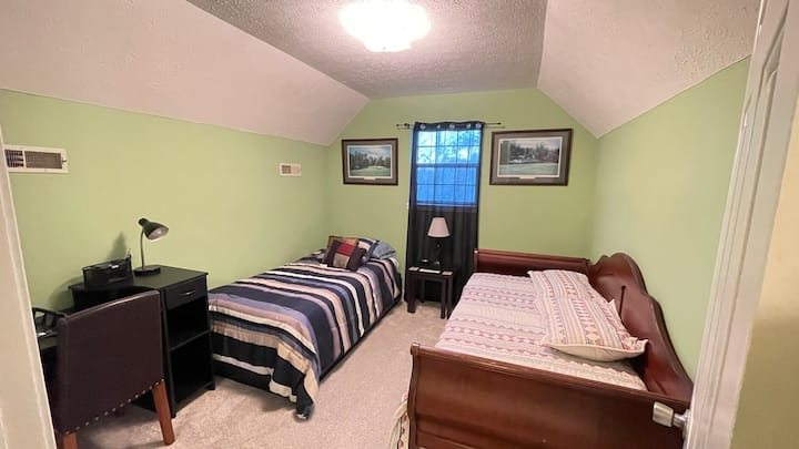 חדר שינה בקומה השנייה עם שתי מיטות יחיד 