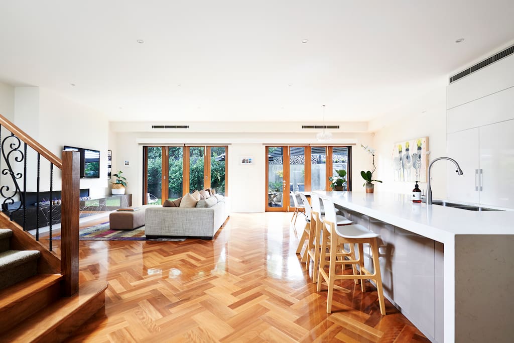 Open plan living dining with bi-fold doors open to private back deck, BBQ and lawned yard.