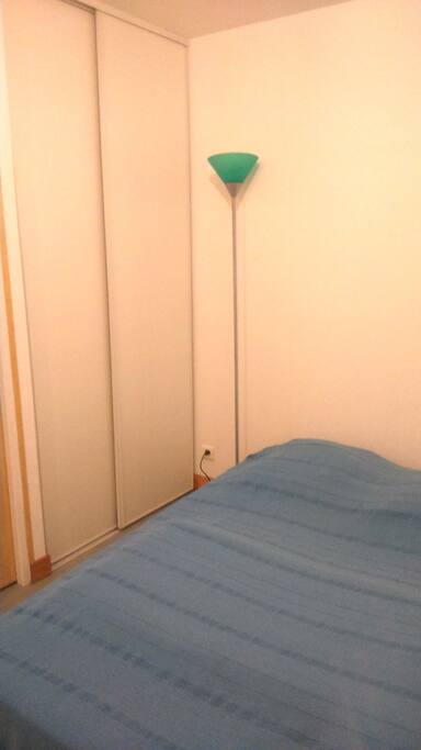 Chambre avec placard, penderie, étagères.