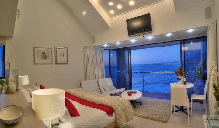 The romantic Starlight Premier Suite has views of the waves below and sparkling lights across the bay