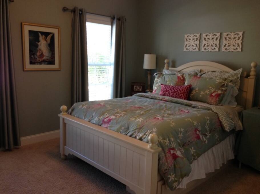 Bedroom with a cozy queen bed, dresser and mirror.
