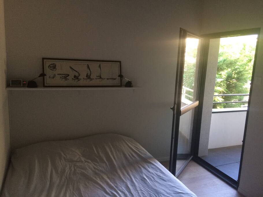 Chambre : accès au balcon et lit quen size