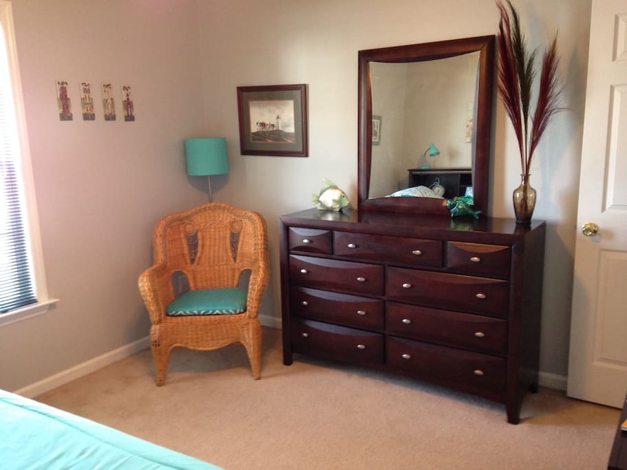 Lots of dresser space and a cozy chair to read in.