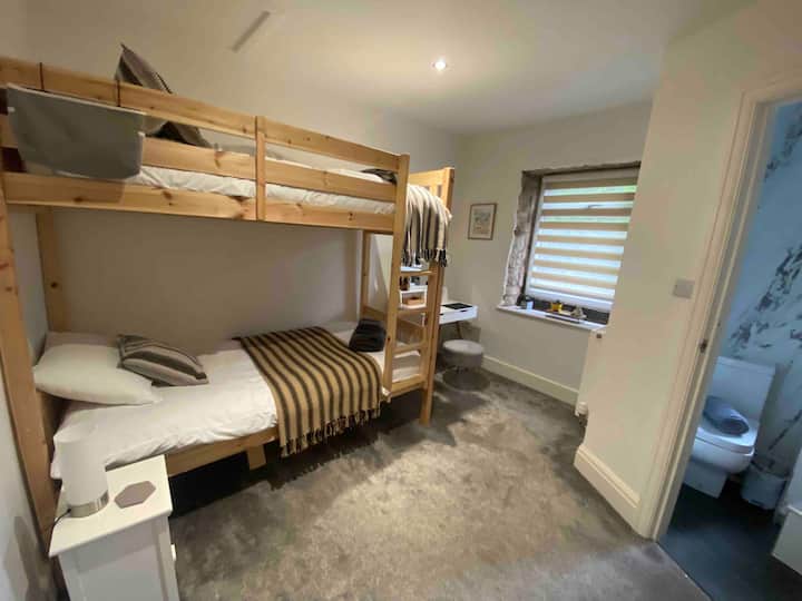 Lits superposés pour adultes avec douche attenante sur baignoire. 