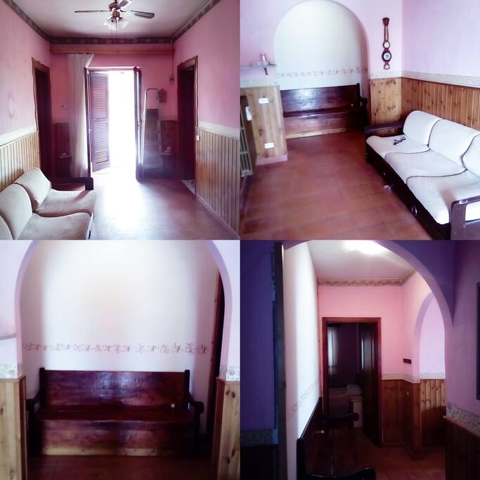 Salone con baule,arco,divano,eporta di ingresso dal balcone.
