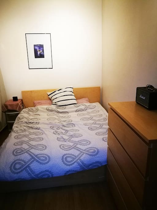 Bedroom with queen sized bed, wardrobe and cupboard.