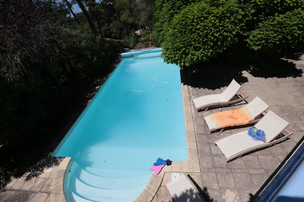 une piscine noyée dans la verdure pour des après midis au calme , un jeu d'échec géant pour le plaisir