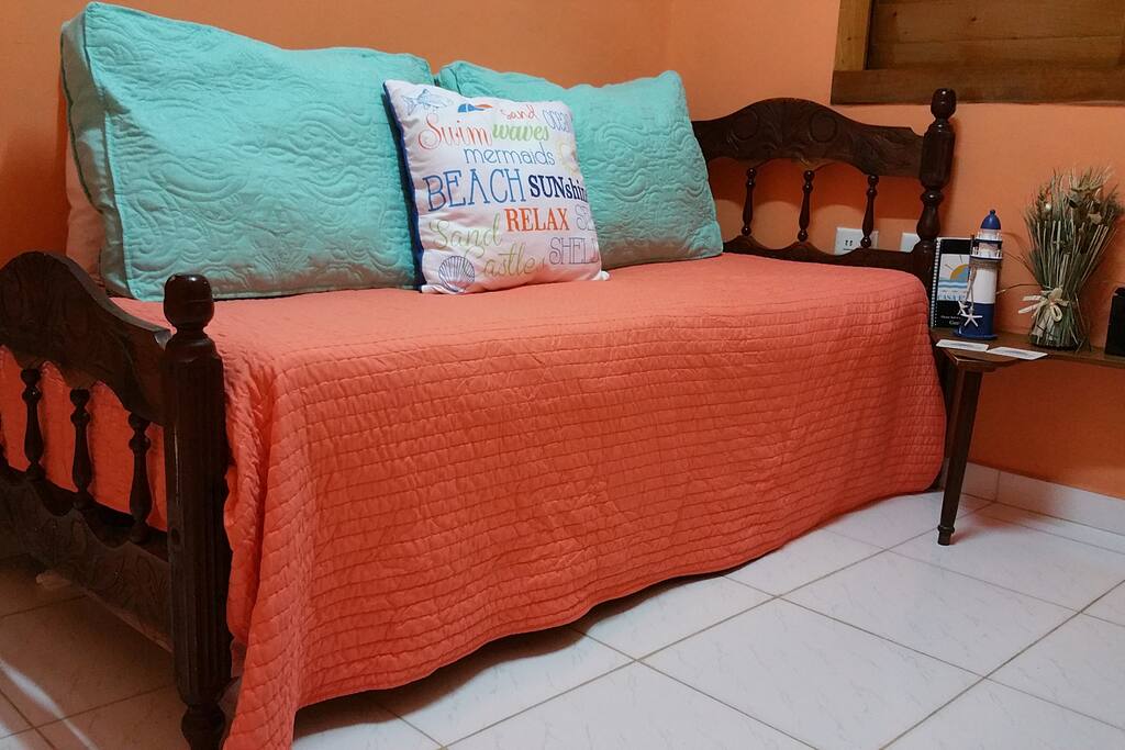 Common space with a single bed and TV