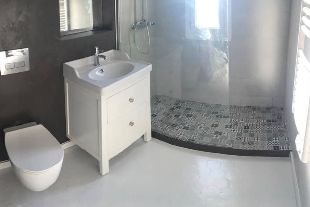 Salle de bain, avec une douche italienne, toilette, lavabo et machine à lavé