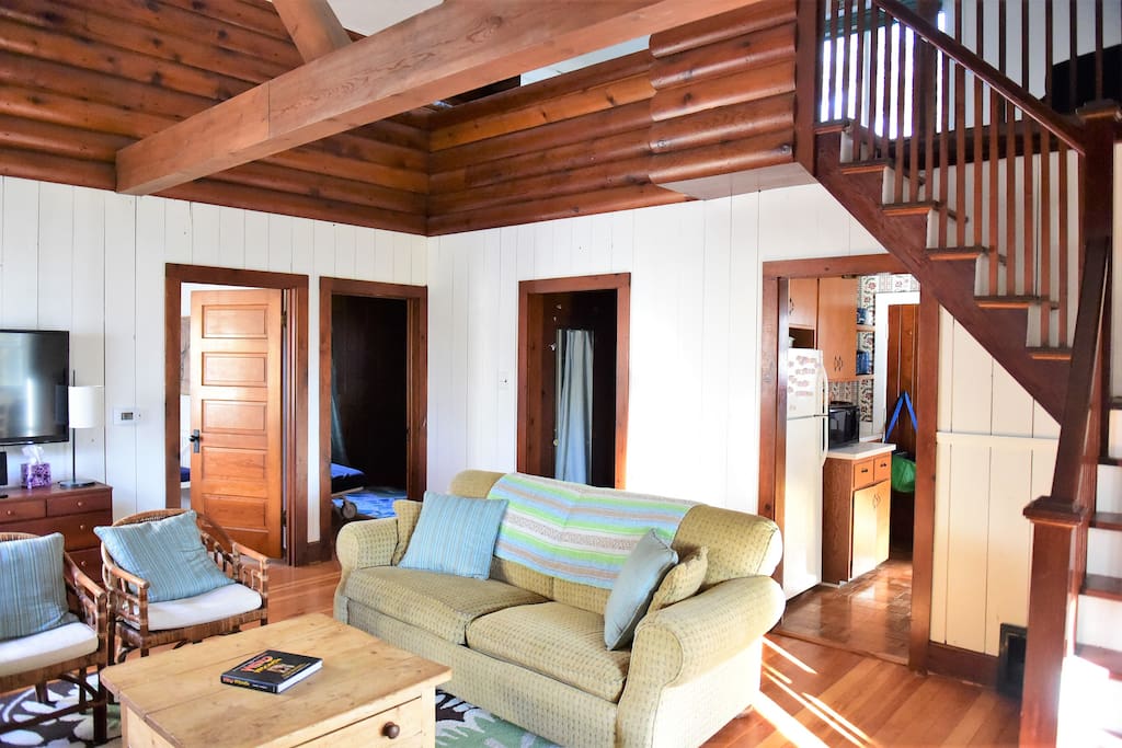 Spacious living room with hardwood floors and floor to ceiling stone fireplace