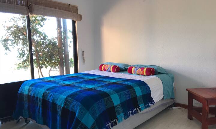 Спалня 1 с изглед към морето и изход към външната част на къщата.
Спалня 1 с изглед към океана и изход към външната страна на къщата.
