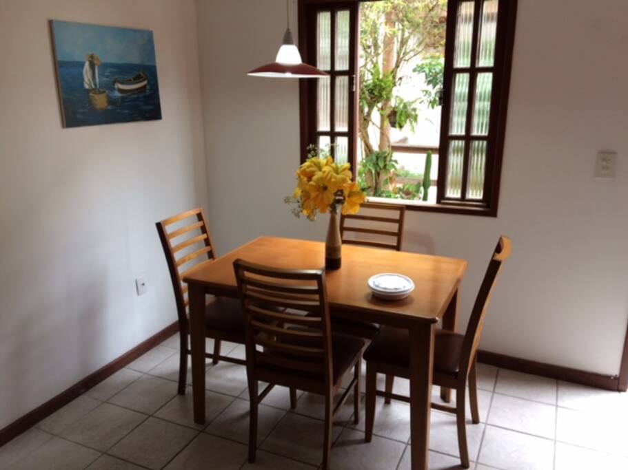 Sala com mesa e quatros cadeiras.