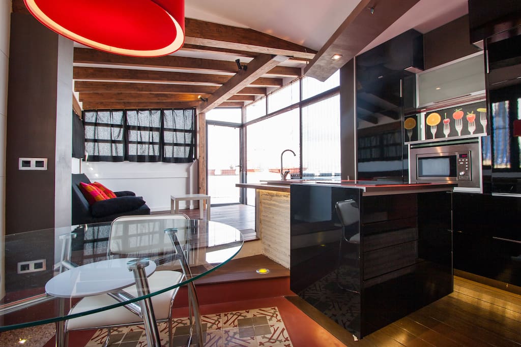 Kitchen area with fridge, microwave, sink, washing machine, table and chairs/Área de cocina con nevera, microondas, fregadero, lavadora, mesa y sillas