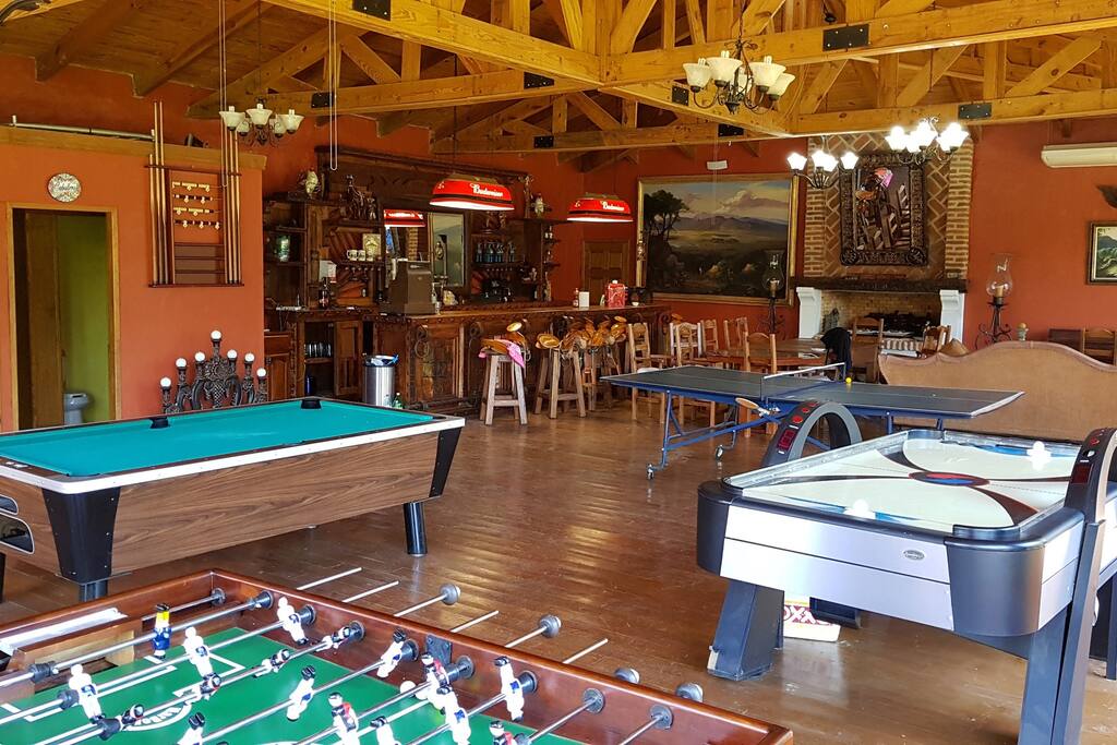 Salon de juegos con pantalla, mesa de billar, ping pong y futbolito