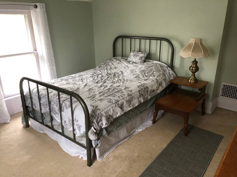 The guest bedroom with one double bed - curtains on both windows, a remote-controlled ceiling fan, an antique dresser and a pastel green color make this room a peaceful place for a good nights' sleep! This room is on the top floor of the house.
