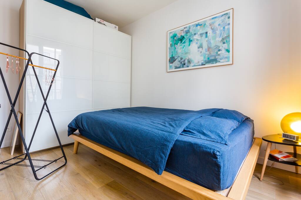 La chambre avec son lit double, son dressing et sa table de chevet