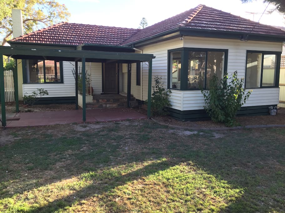 View of the home from the front garden, includes off-street parking under carport