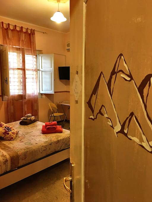 il Cairo è una camera matrimoniale dotata di bagno privato, aria condizionata, TV. come per le altre camere della Casa è arredata a tema// Cairo is a double room with bathroom, air conditioner and TV. Like the other rooms in the house this is also decorated with theme.
