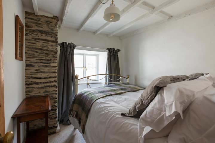 Мала двокреветна соба со антички брачен кревет и поглед напред.