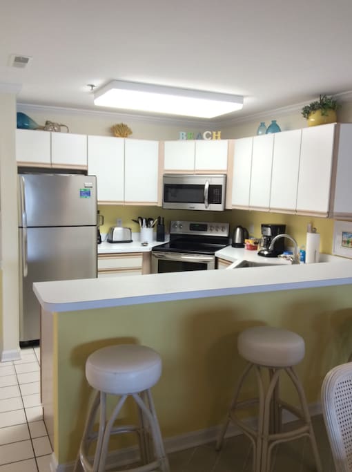 Kitchen with raised counter and bar stools