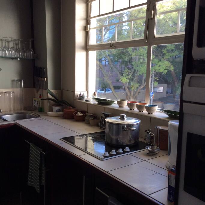 The kitchen features an electric hob, a microwave, oven, coffee maker and toaster