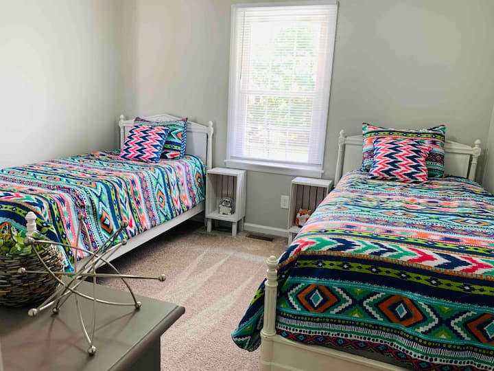 El cuarto dormitorio recién alfombrado tiene dos camas individuales perfectas para niños, pero lo suficientemente cómodas para adultos. 