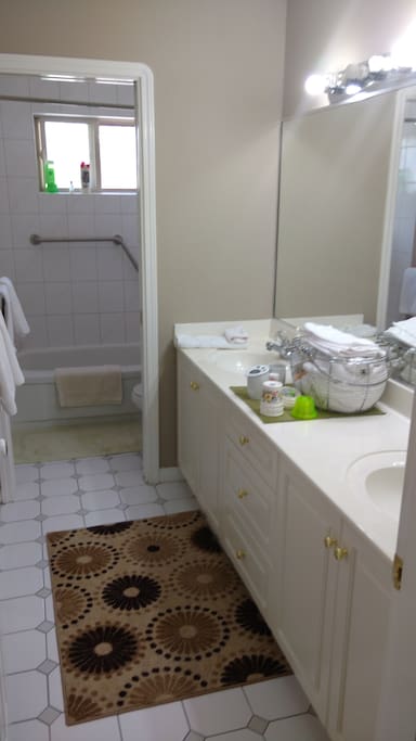 Private bath with double sink and bathtub.