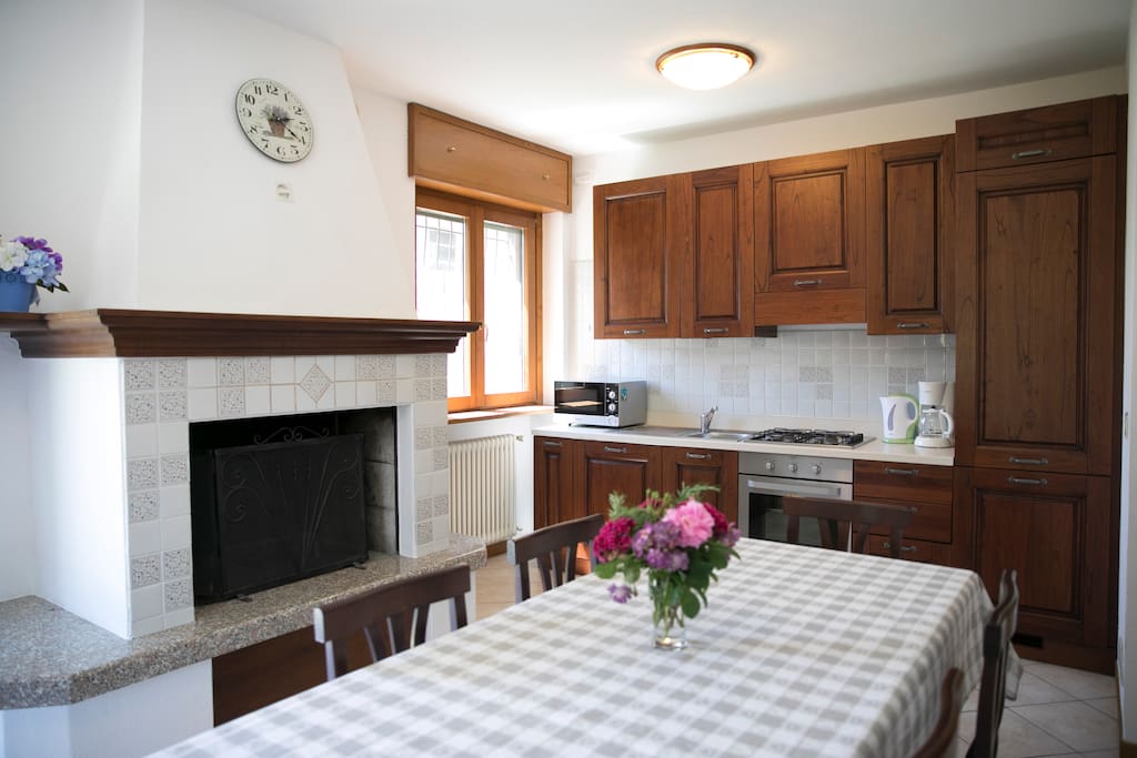 Kitchen with dishwasher, fridge, freezer, microwave, coffee machine, water heater, fire place, babychair and plastic dishes for children