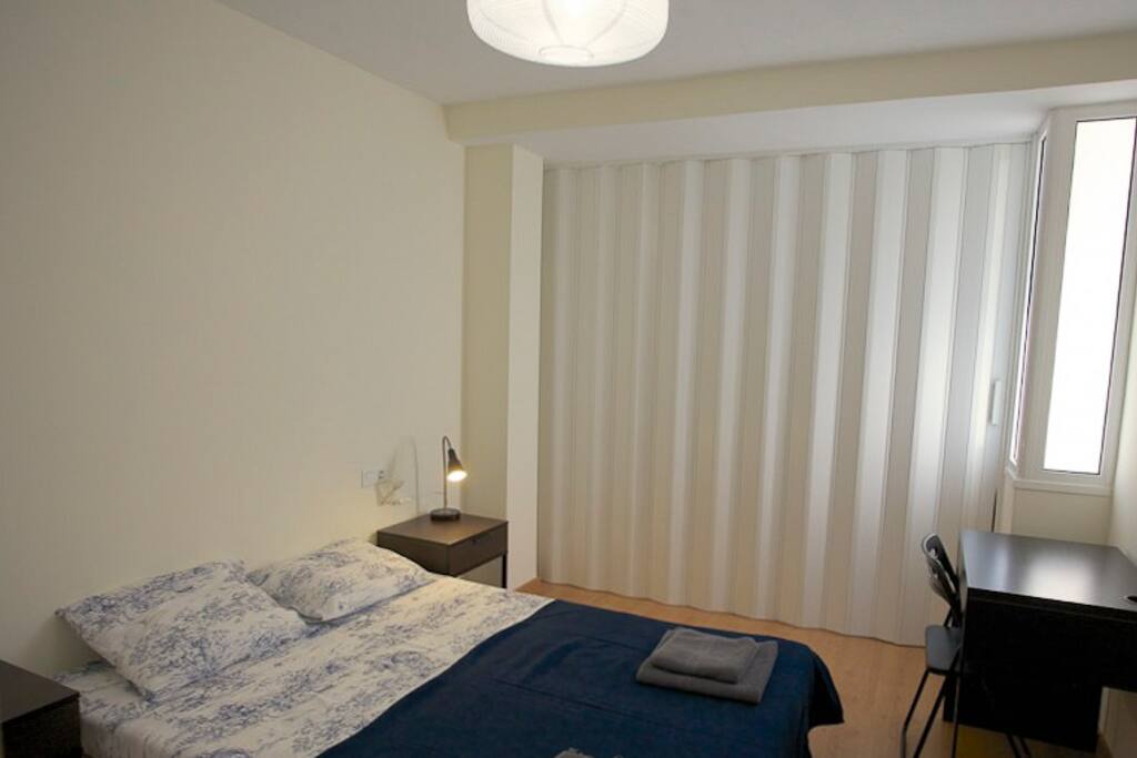 Amplia habitación con dos camas de matrimonio y puerta corredera de separación cerrada.
