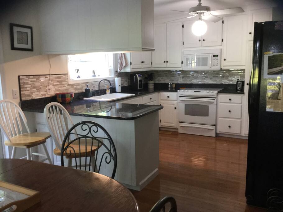 Full kitchen with bar and granite countertops.