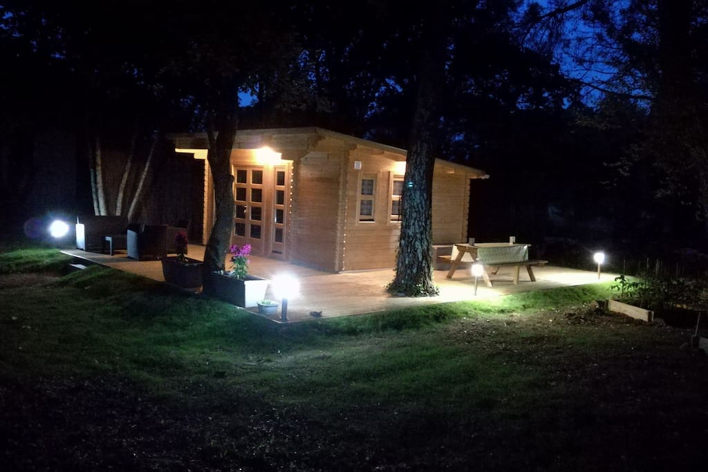 La terrasse de 40 mètres carrés avec sa table en bois et ses deux bancs la nuit.