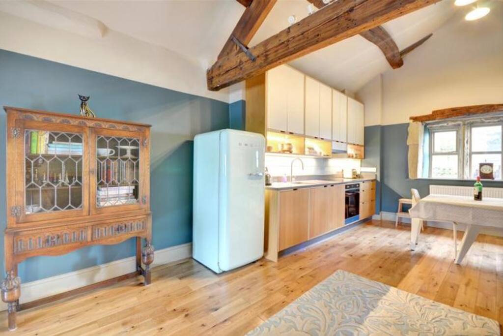 Hand-built kitchen with Smeg induction hob and oven, Smeg fridge, and a dishwasher hiding in a cupboard