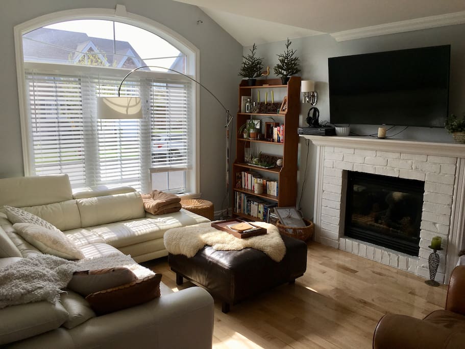 Cozy living room includes a 55’’ curvy smart tv and a gas fireplace