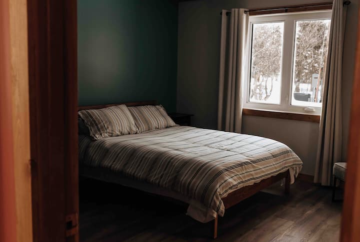 Guest Bedroom with a cozy Queen Size bed and south facing window - incase you want to catch that beautiful Saskatchewan sunset from the comfort of your own bed!