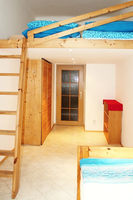 Bedroom 1 with single bed on the floor and two single beds up the ledder.
