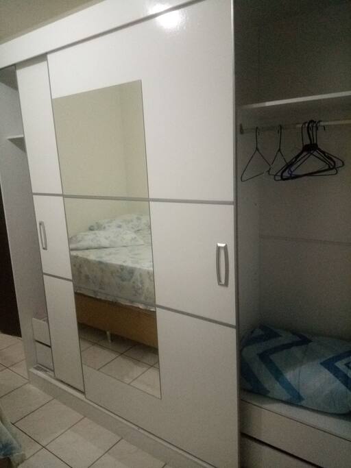 Armário com cabides e espelho na porta.