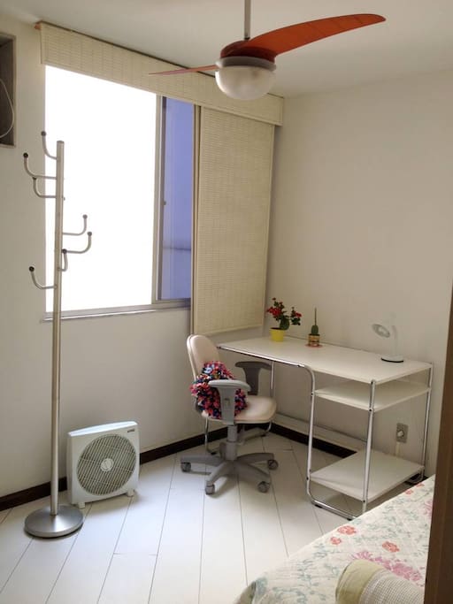 Quarto com janela,ventilador de teto, cabideiro.