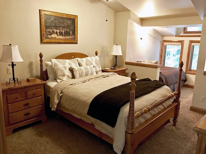 Dormitorio grande en la parte superior oeste con una cama tamaño queen y dos camas individuales