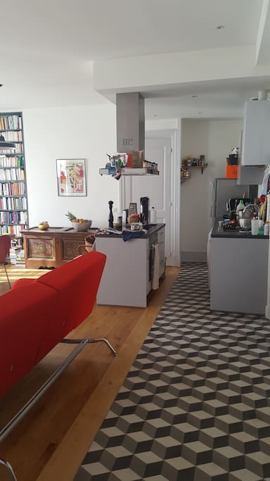 Entrée dans la pièce centrale avec cuisine américaine / Entering the living room, which includes a kitchen