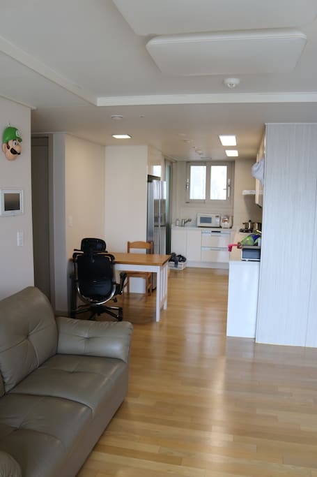 A clean kitchen with a fridge, an oven, a rice-cooker and a microwave