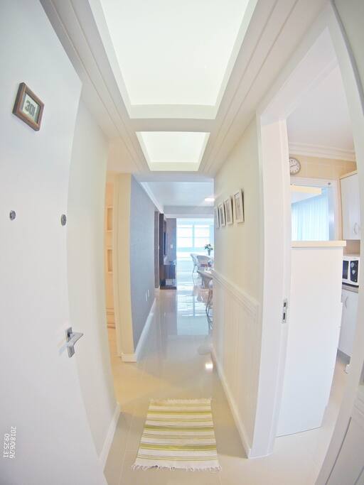 Hall de entrada do apartamento. À direita a cozinha com lavanderia, à esquerda dois quartos e banheiro social.