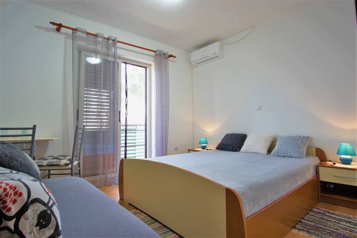 Chambre avec grand lit double
 un lit et des places assises pour deux personnes.