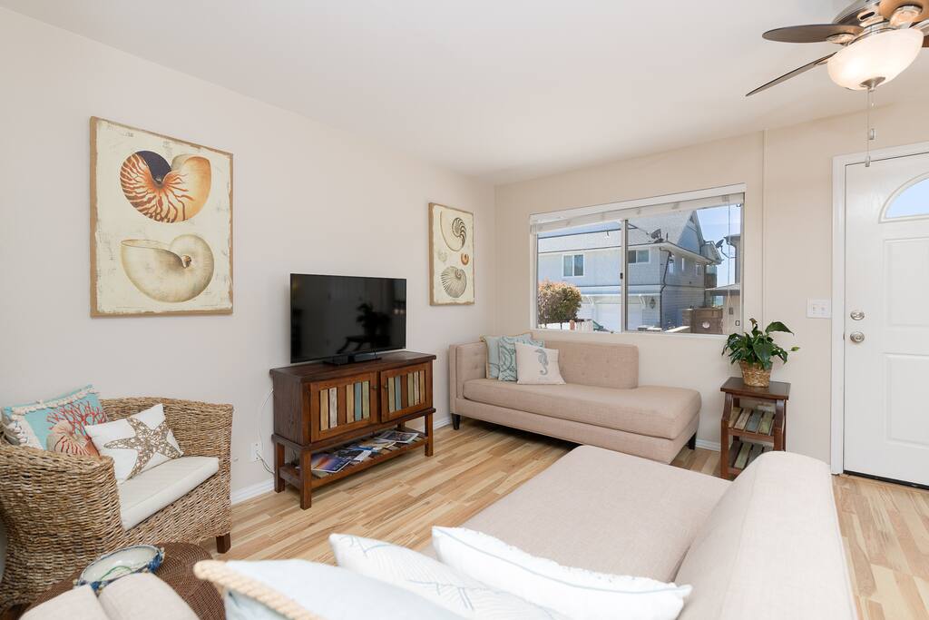 Living room, open and breezy with a peak ocean view!
