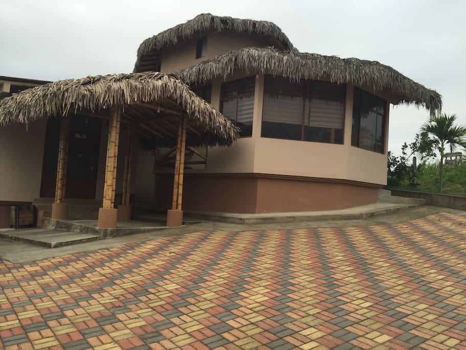 Vista frontal de casa, área social y parqueadero