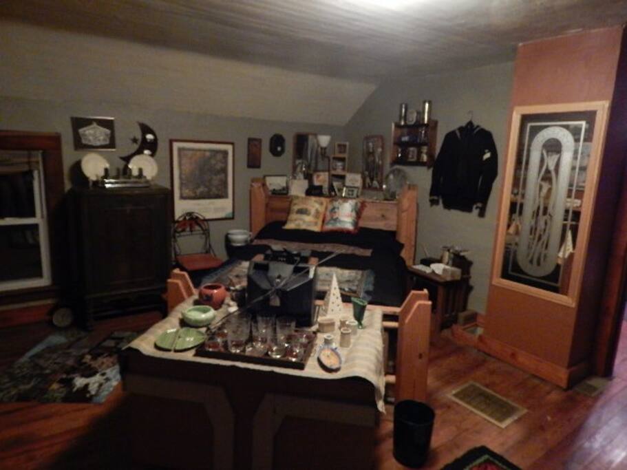 upstairs guest room with full size bed and lots of unique decor