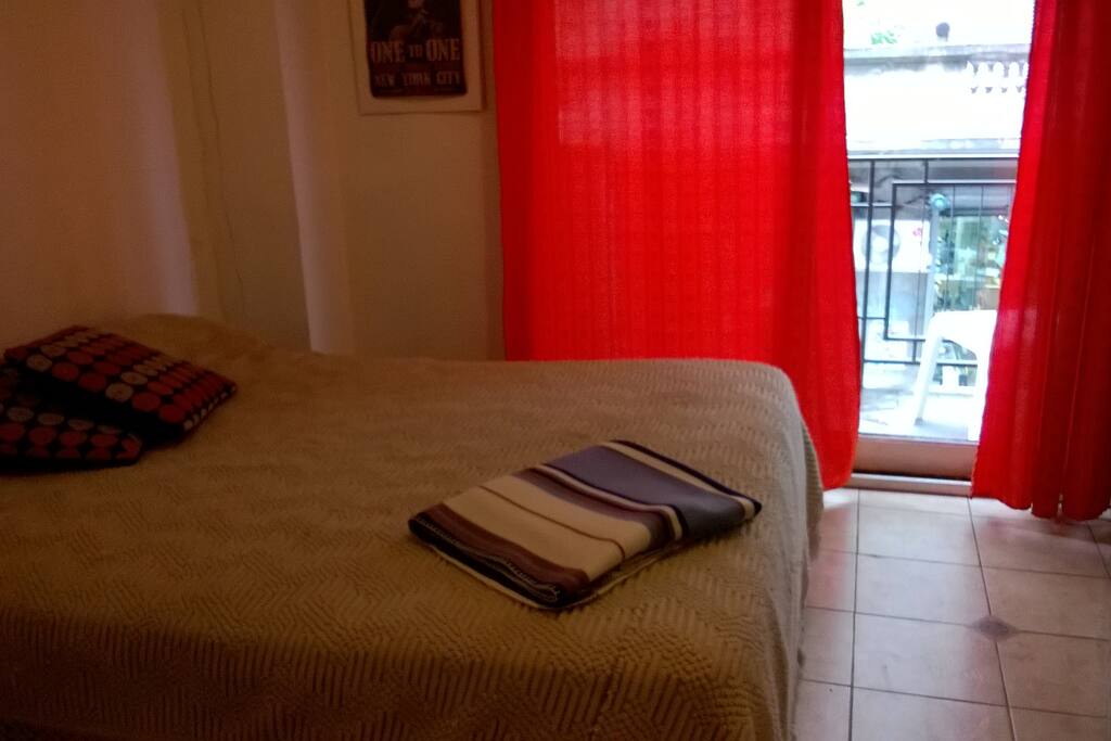 Habitación para dos personas con cama doble y salida a balcón con vista a calle Sarmiento. Calefacción.